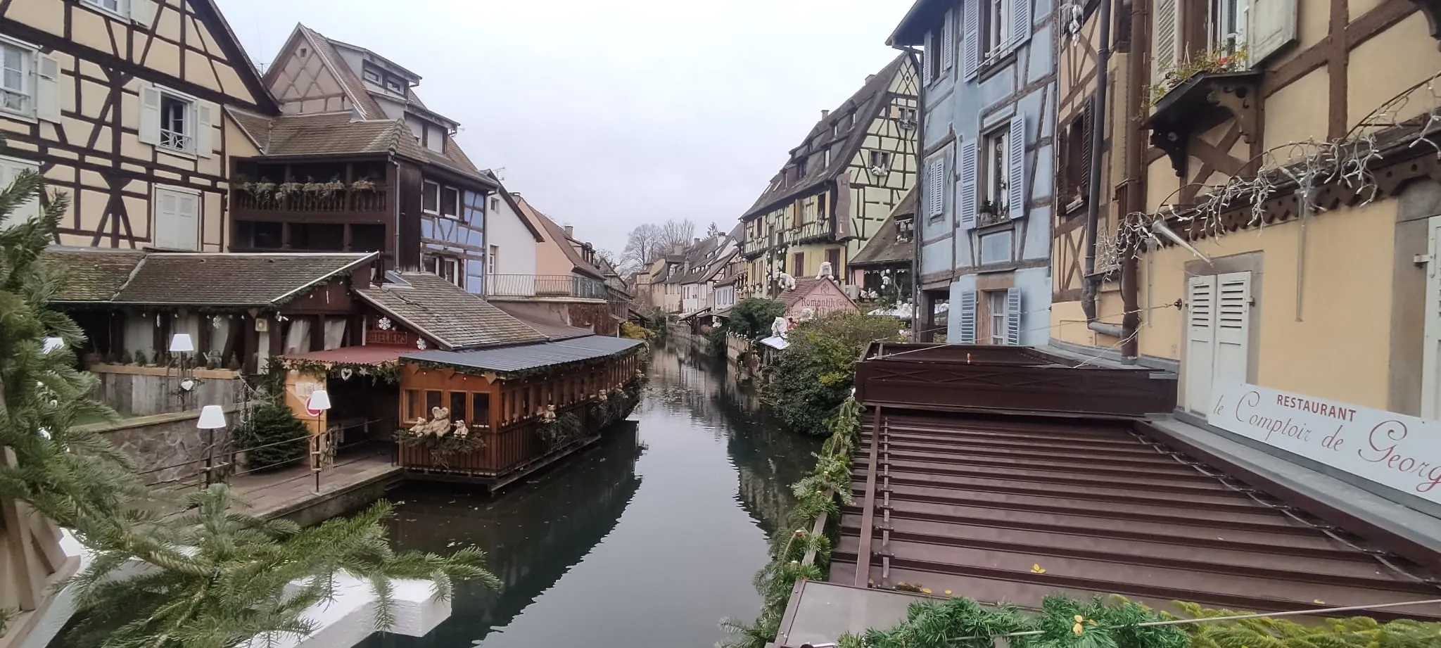 Canal de Petite Venise en Colmar con casas de entramado de madera y un barco-restaurante tradicional
