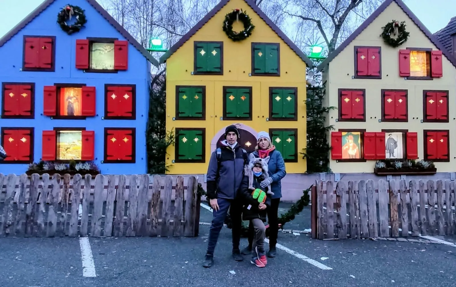 Familia frente a un calendario de Adviento gigante en un pueblo de Alsacia, diciembre de 2021