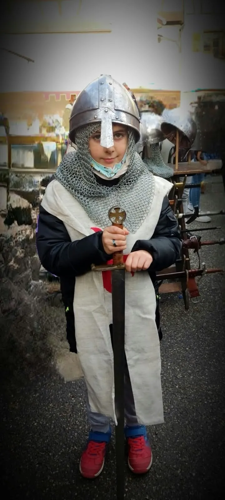 Niño con cota de malla, casco y espada en el mercado medieval de Ribeauvillé